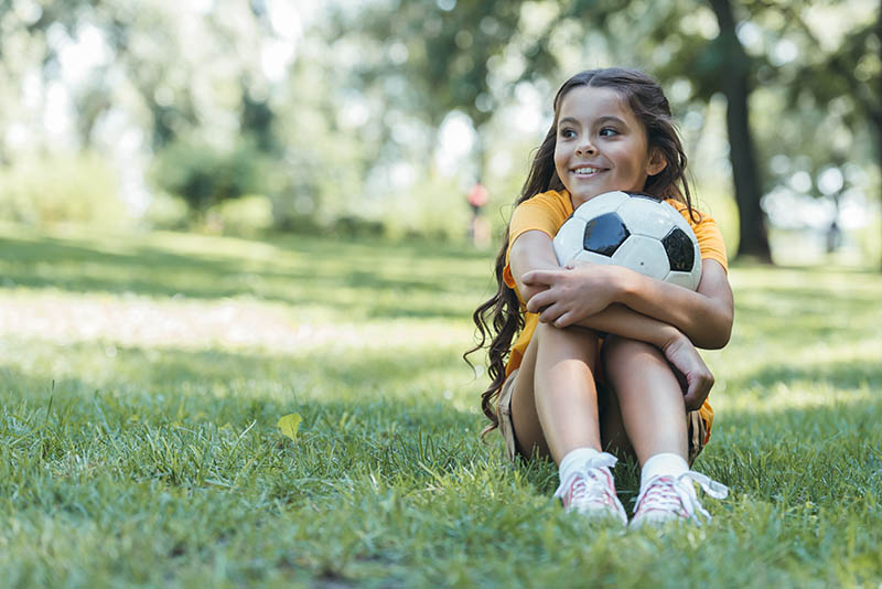 Young child holding soccer ball in park