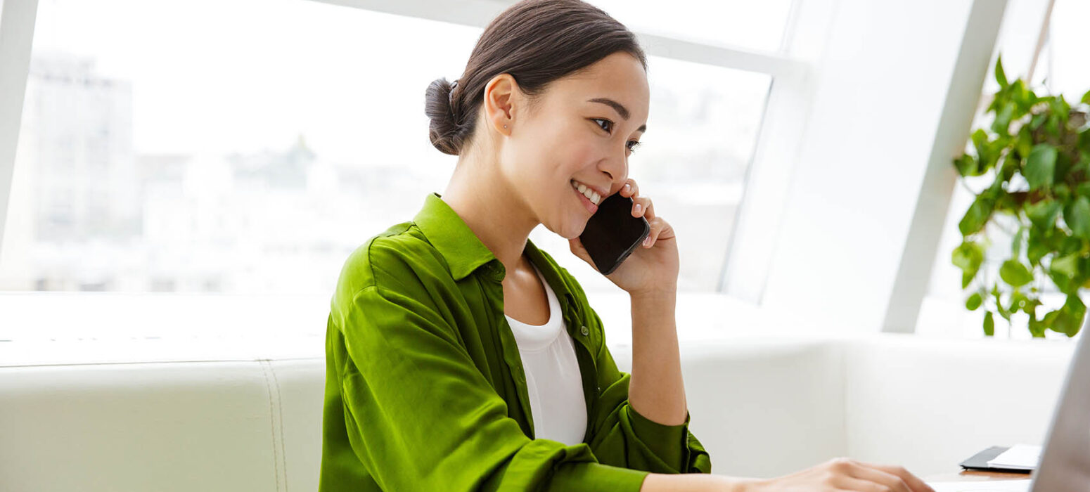 Smiling beautiful young woman working on laptop